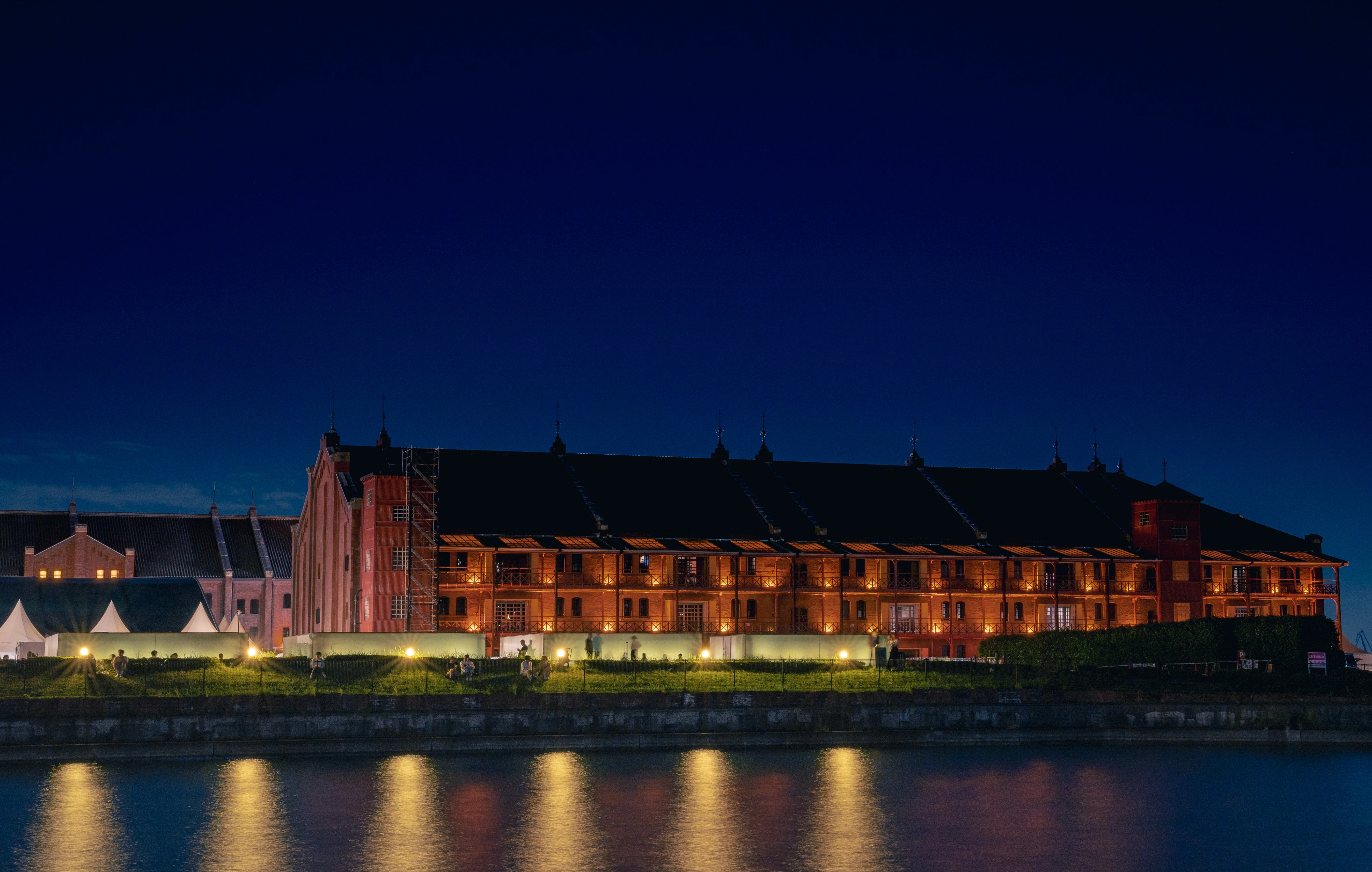 Illuminated Red Brick Warehouse by the Waterfront at Night